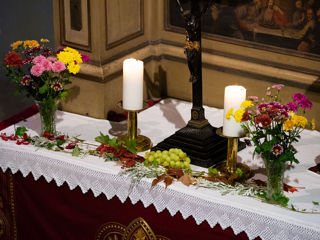Altar mit Kreuz, Kerzen und Ernteschmuck